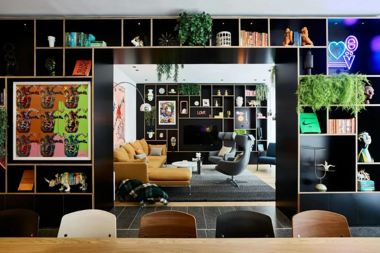 a living room with a yellow couch and a tv at citizenM London Victoria Station in London